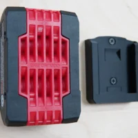 Bosch 18v battery holder mount shown next to a battery, with red grip pattern and black sides