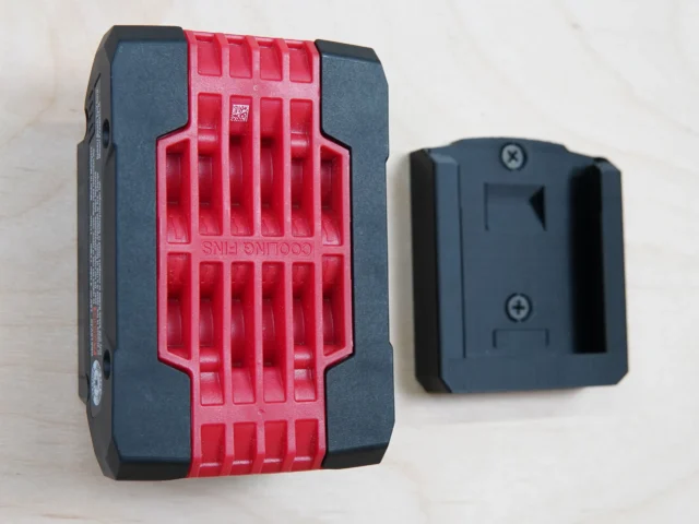 Bosch 18v battery holder mount shown next to a battery, with red grip pattern and black sides