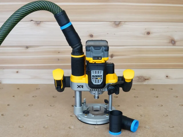 Black 27mm hose adapter with blue band on a DeWalt 20V XR plunge router, second adapter resting alongside