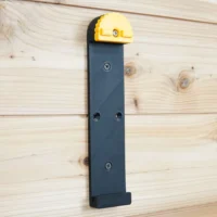 Wall mount for Dewalt track saw rail with yellow locking lever, dark blue bracket, and three mounting holes on light wood