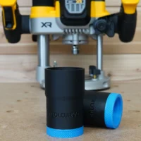 Black and blue hose adapter with ToolCurve branding, shown in front with DeWalt plunge router blurred in background