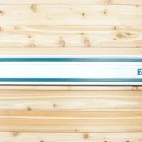 Makita track saw guide rail mounted on wooden wall with two teal circular locking mounts at ends and black grip pads