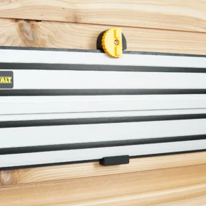 DeWalt guide rail hanging on a wood-plank wall from a black wall mount with yellow locking knob