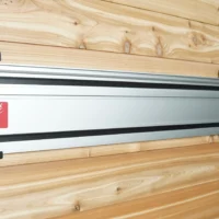 Red wall mounts securing a Milwaukee track saw rail to wooden wall studs