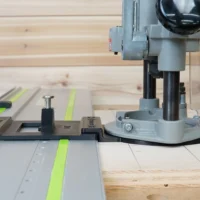 Porter Cable 690 router with LR 32 drilling jig mounted on Festool track, showing spring-loaded knob and guide rail stops positioned on plywood