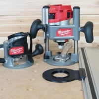 Guide rail adapter for Milwaukee M18 2-1/4HP router mounted on plunge base, displayed on workbench with track saw rail