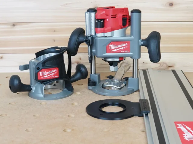 Guide rail adapter for Milwaukee M18 2-1/4HP router mounted on plunge base, displayed on workbench with track saw rail