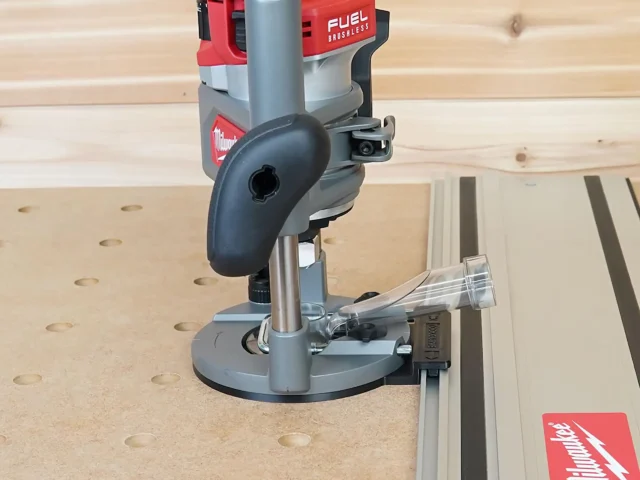 Milwaukee M18 router with guide rail adapter mounted on Kreg track rail, positioned over wooden workpiece with pocket holes