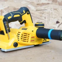 Hose adapter with blue band attached to dust port of yellow and black Dewalt cordless planer