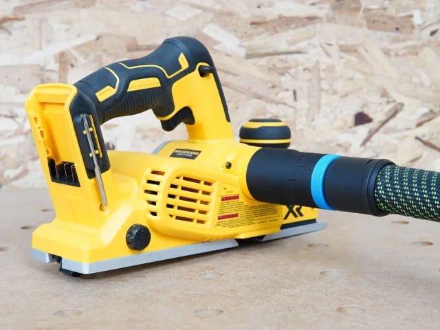Hose adapter with blue band attached to dust port of yellow and black Dewalt cordless planer