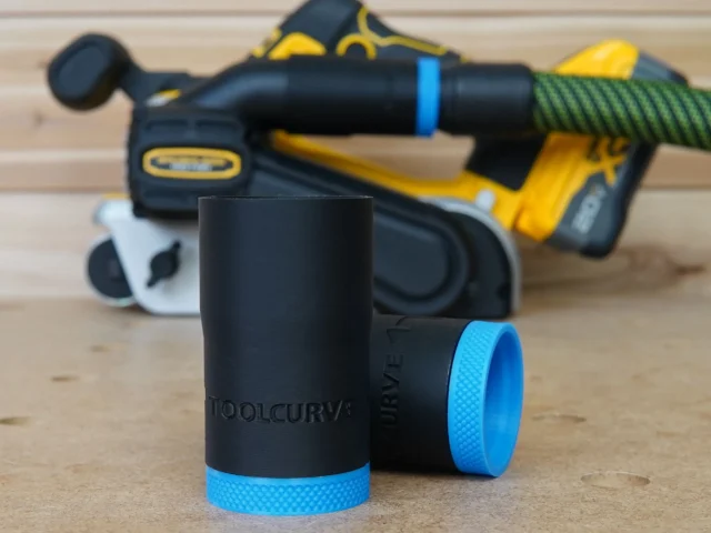Black hose adapter with blue grip bands for Dewalt belt sander, shown disassembled in foreground with sander blurred in background