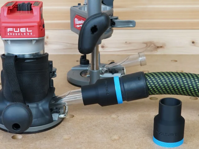Black ToolCurve 36mm hose adapter with blue band joining a vacuum hose beside a Milwaukee M18 router