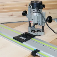 Porter Cable 690 router mounted on LR 32 adapter plate aligned over Festool track rail, with guide rail stops positioned at each end on wooden workbench