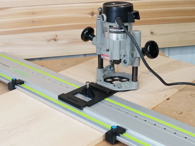 Porter Cable 690 router mounted on LR 32 adapter plate aligned over Festool track rail, with guide rail stops positioned at each end on wooden workbench