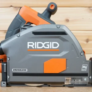 Orange arbor dust cover snapped onto the side of a gray Ridgid brushless track saw, side view