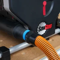Black hose adapter attached to SawStop Compact table saw rear port, with blue and orange hose connectors visible