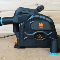 Black 1-1/4 inch hose adapter with blue collar joining an orange hose to a Wen track saw dust port, spare adapters beside it