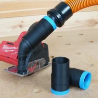 Black 1-1/4" hose adapter with blue cuff joining an orange hose to a Milwaukee M12 Fuel cut out tool, spare adapters alongside