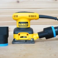 Black 1-7/8" hose adapter with blue band beside a Dewalt palm sander, second adapter joining hose to dust port