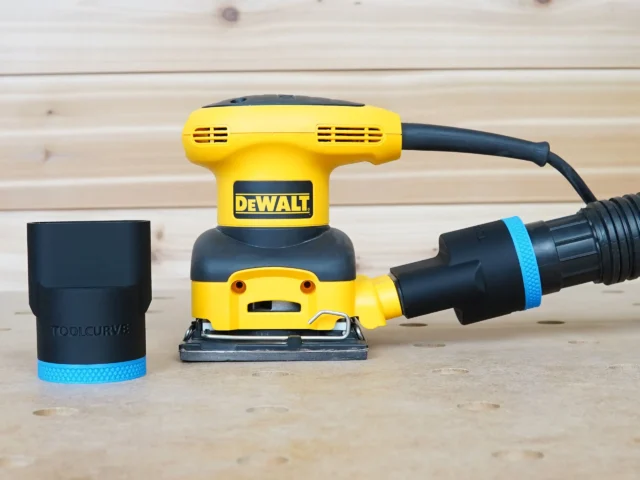 Black 1-7/8" hose adapter with blue band beside a Dewalt palm sander, second adapter joining hose to dust port