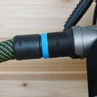 Black hose adapter with blue band attached to green-and-black braided hose, connected to Metabo HPT miter saw port