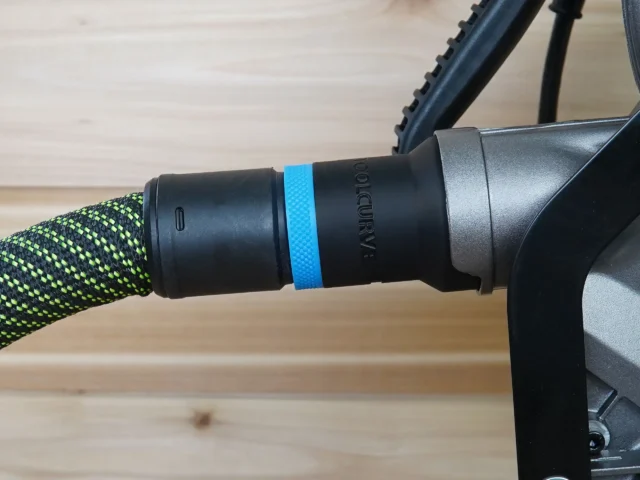 Black hose adapter with blue band attached to green-and-black braided hose, connected to Metabo HPT miter saw port