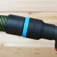 Black ToolCurve 36mm hose adapter with blue band joining a green dust hose to a Milwaukee track saw port