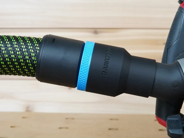 Black ToolCurve 36mm hose adapter with blue band joining a green dust hose to a Milwaukee track saw port