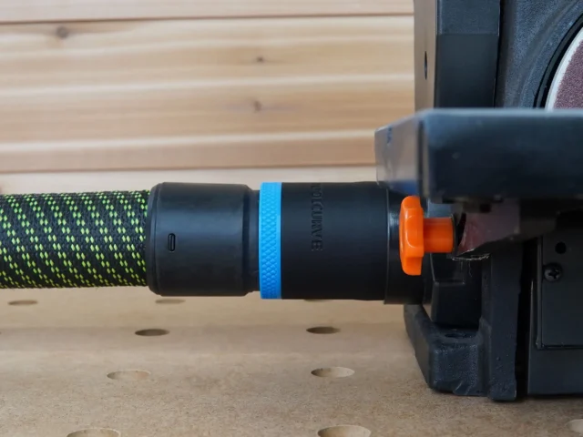 Black ToolCurve 36mm hose adapter with blue band joining a green hose to a Wen belt and disc sander dust port