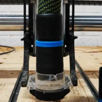 Black 36mm hose adapter with blue band installed on an Onefinity CNC Suck It Dust Boot Pro over a spoilboard
