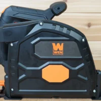 Side view of a WEN track saw with the orange 7-1/4 in. arbor dust cover snapped over the blade housing
