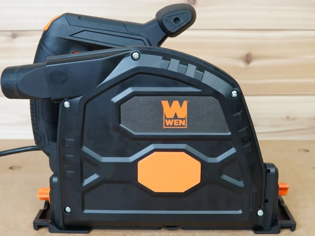 Side view of a WEN track saw with the orange 7-1/4 in. arbor dust cover snapped over the blade housing