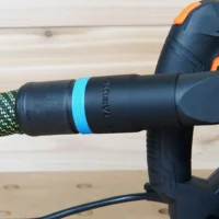 Black hose adapter with blue band attached to Wen track saw, connected to green braided hose