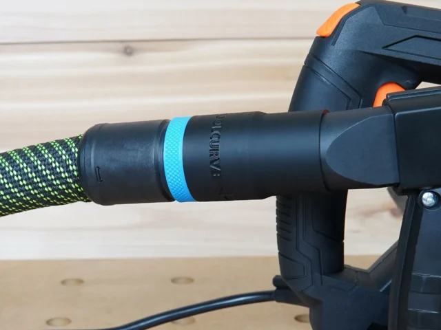 Black hose adapter with blue band attached to Wen track saw, connected to green braided hose