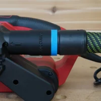 ToolCurve hose adapter attached to SKIL belt sander, with blue band and green braided hose connected