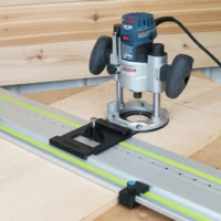 Black LR32 rail adapter with plunge base attached to Bosch Colt router mounted on guide rail with Festool track, showing stop blocks and registration plate