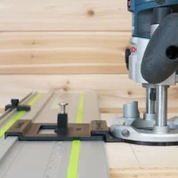 Bosch Colt plunge router mounted on LR 32 rail system with adapter and stop blocks on Festool track, ready for hole drilling