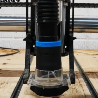 Black 1-7/8 inch hose adapter with blue grip ring installed on an Onefinity CNC Suck It dust boot