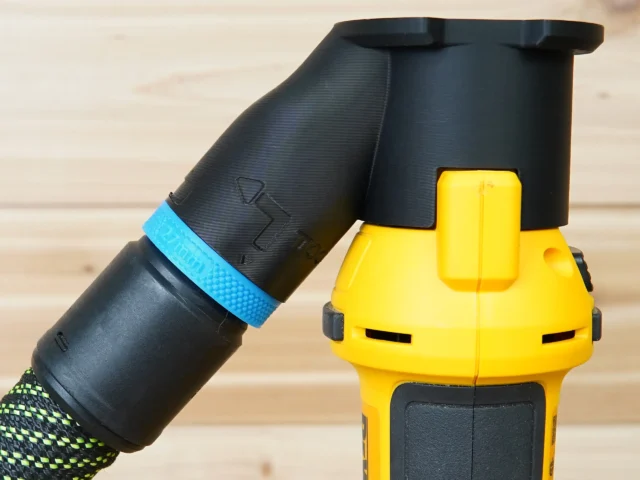 Black hose adapter with blue band attached to yellow Dewalt drywall cut out tool dust port
