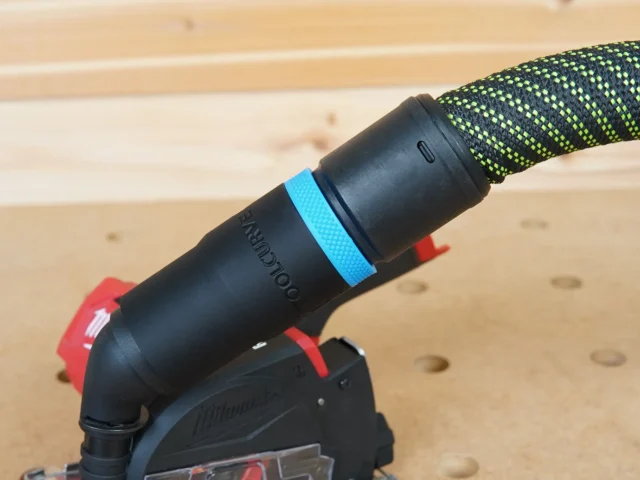 Black hose adapter with blue grip band attached to Milwaukee 12v cut out tool with green and black hose connected