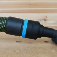 Black ToolCurve 36mm hose adapter with blue ring joining a green vacuum hose to a DeWalt disc sander dust port