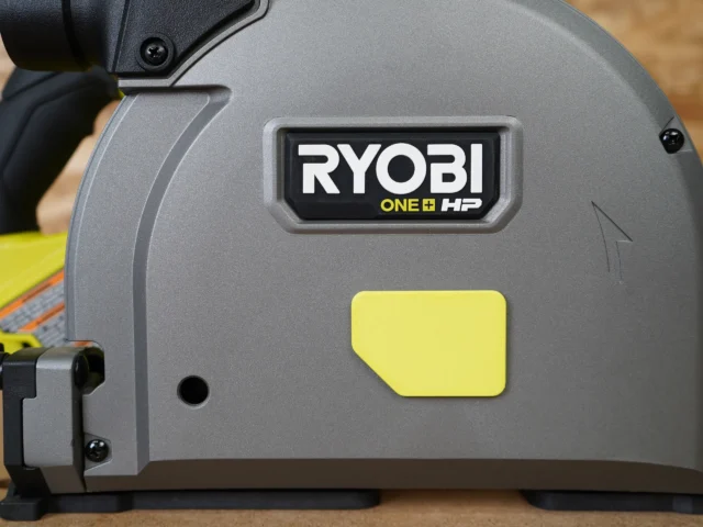 ToolCurve track saw dust cover with yellow snap-on panel attached to Ryobi One+ HP track saw