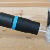 Black hose adapter with blue band attached to Kobalt 24v router dust port, connected to Festool hose