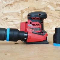 Black ToolCurve 36mm hose adapter with blue band joining a vac hose to a Milwaukee 1/4 sheet sander, plus a spare adapter