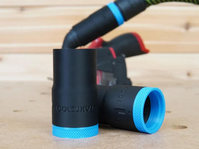 Black ToolCurve hose adapter with blue textured ring, shown alone and attached to Milwaukee 12v Cut Out Tool in background