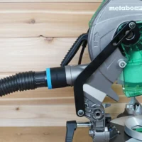Black 1-7/8 inch hose adapter with blue band installed on Metabo HPT miter saw dust port with hose attached