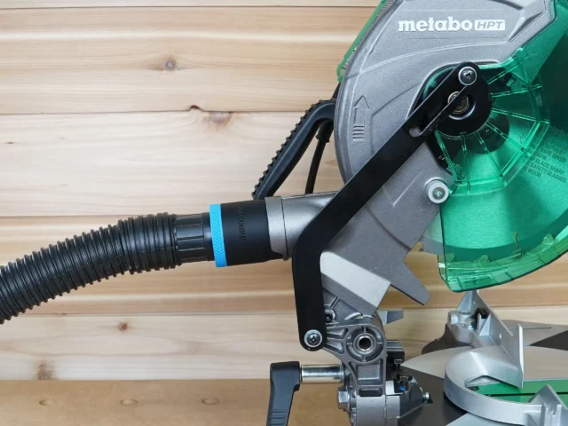 Black 1-7/8 inch hose adapter with blue band installed on Metabo HPT miter saw dust port with hose attached