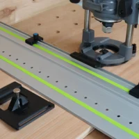 Milwaukee M18 router mounted on LR 32 rail system with plunge base, guide rail stops, and hole drilling setup on wooden workbench