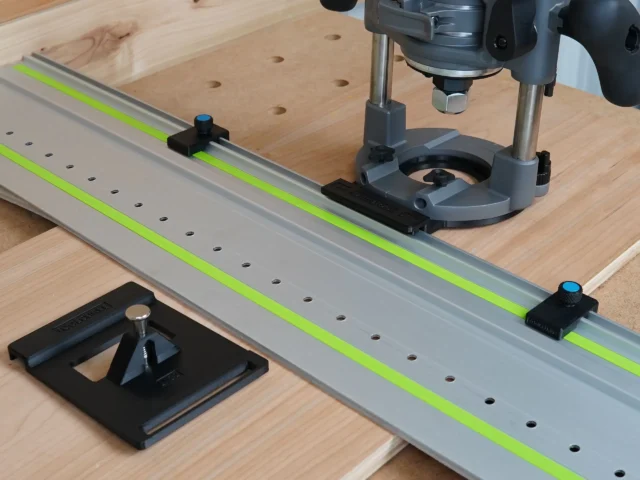 Milwaukee M18 router mounted on LR 32 rail system with plunge base, guide rail stops, and hole drilling setup on wooden workbench