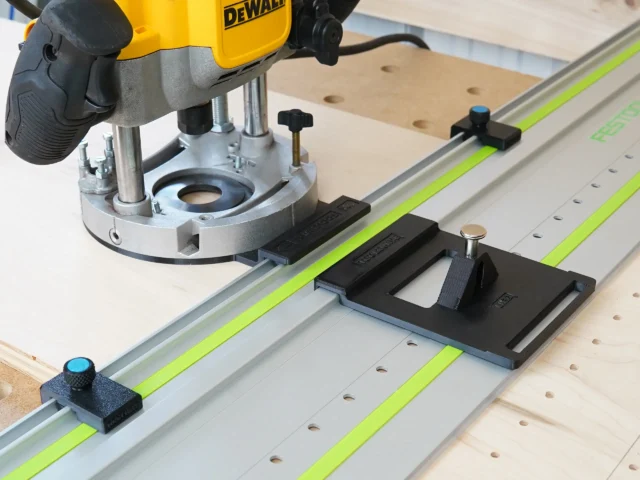 Dewalt 625 router mounted on LR 32 rail system with black adapter plate, guide stops, and spring-loaded knob on Festool-style track